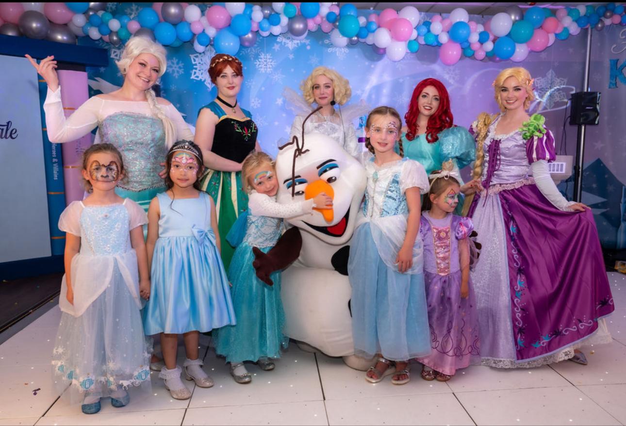 Princesses, fairy godmother and children dressed as princesses at a party